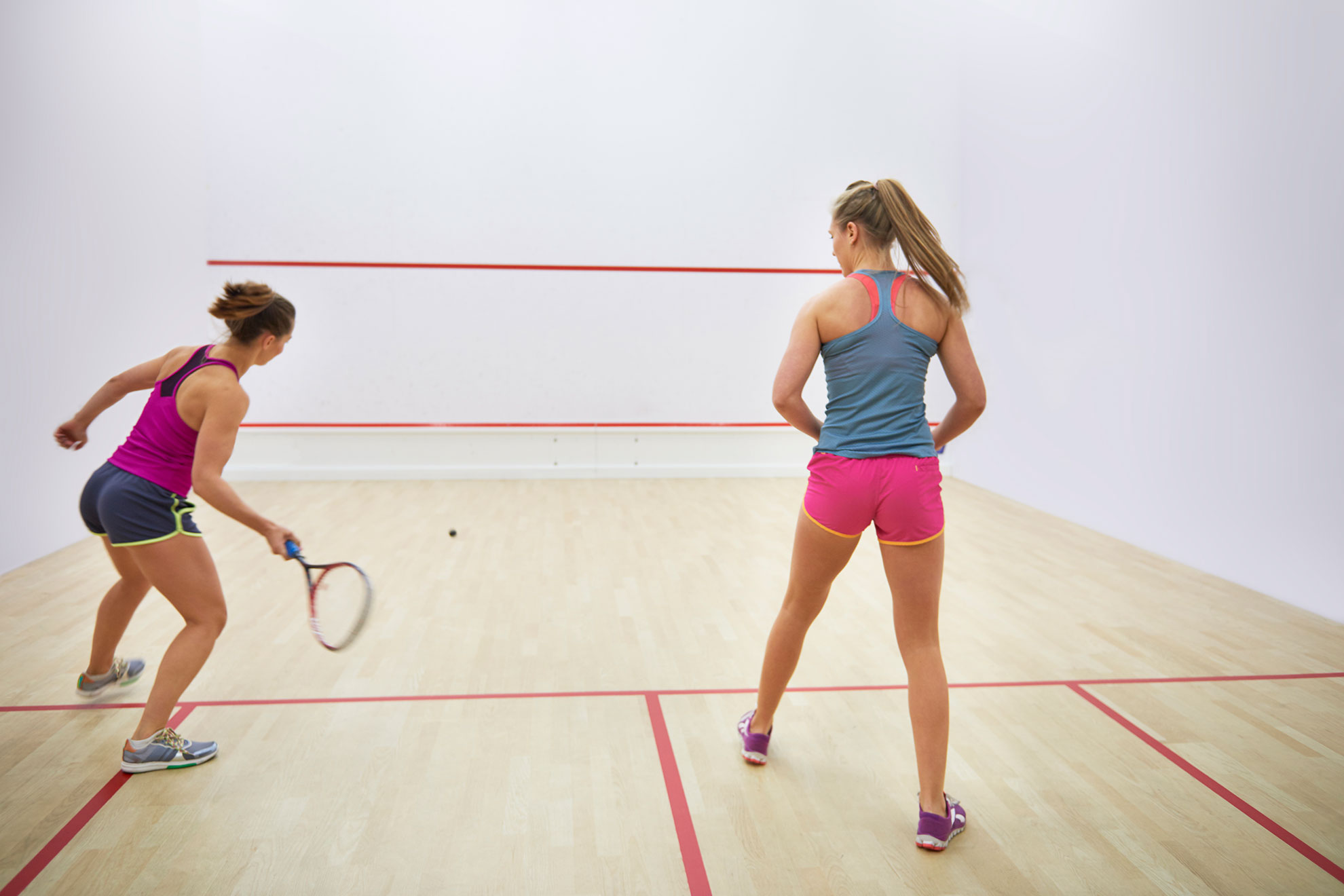 Dwie zawodniczki grające w squasha, ilustracja do artykułu o piłce z białą kropką